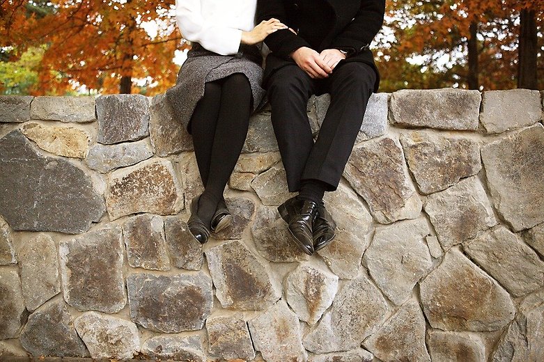Par som sitter på en mur